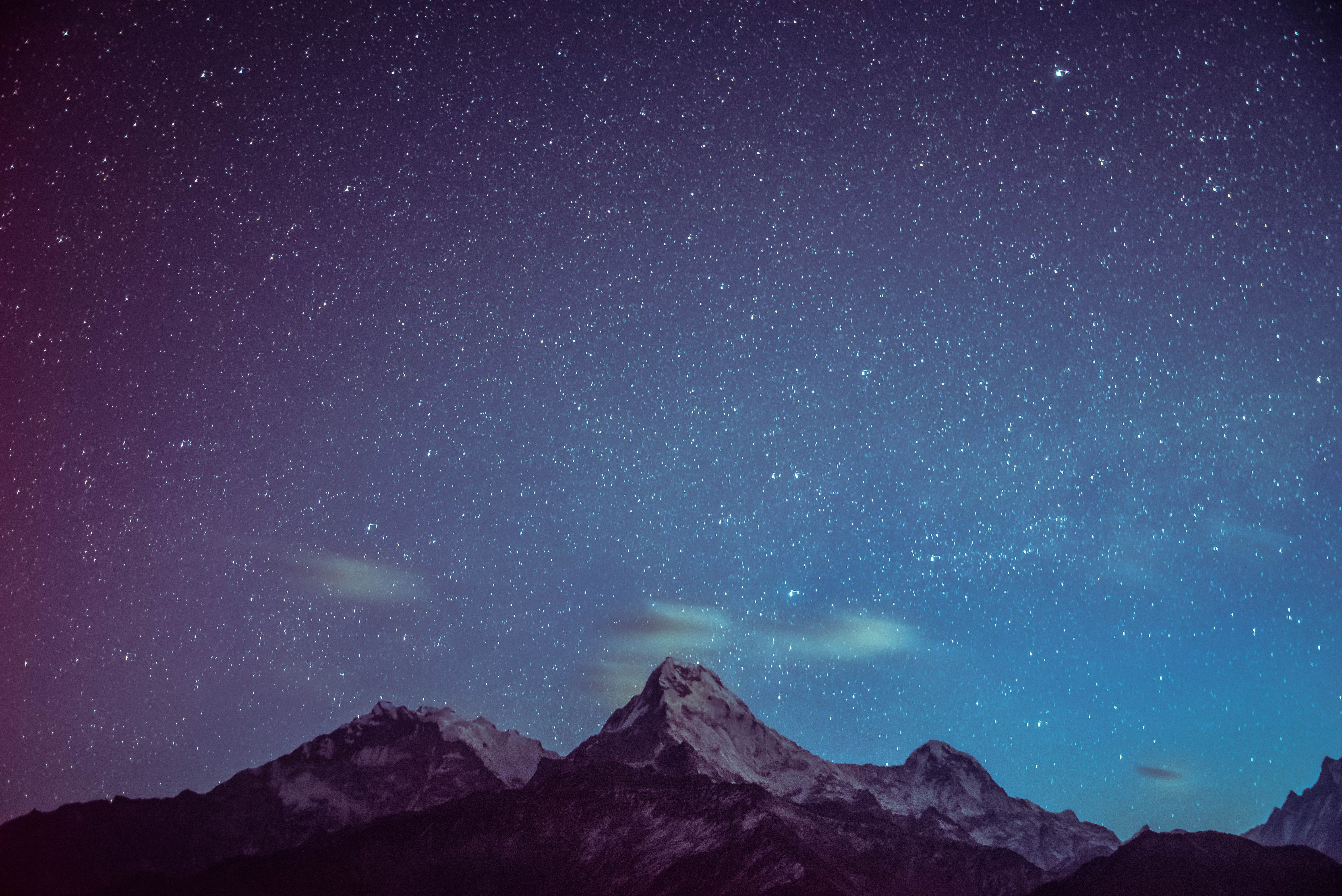 large starry night sky with mountain range in distance